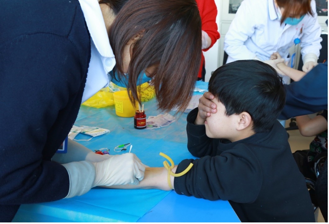 Children in Linfen Red Ribbon School receiving physical test